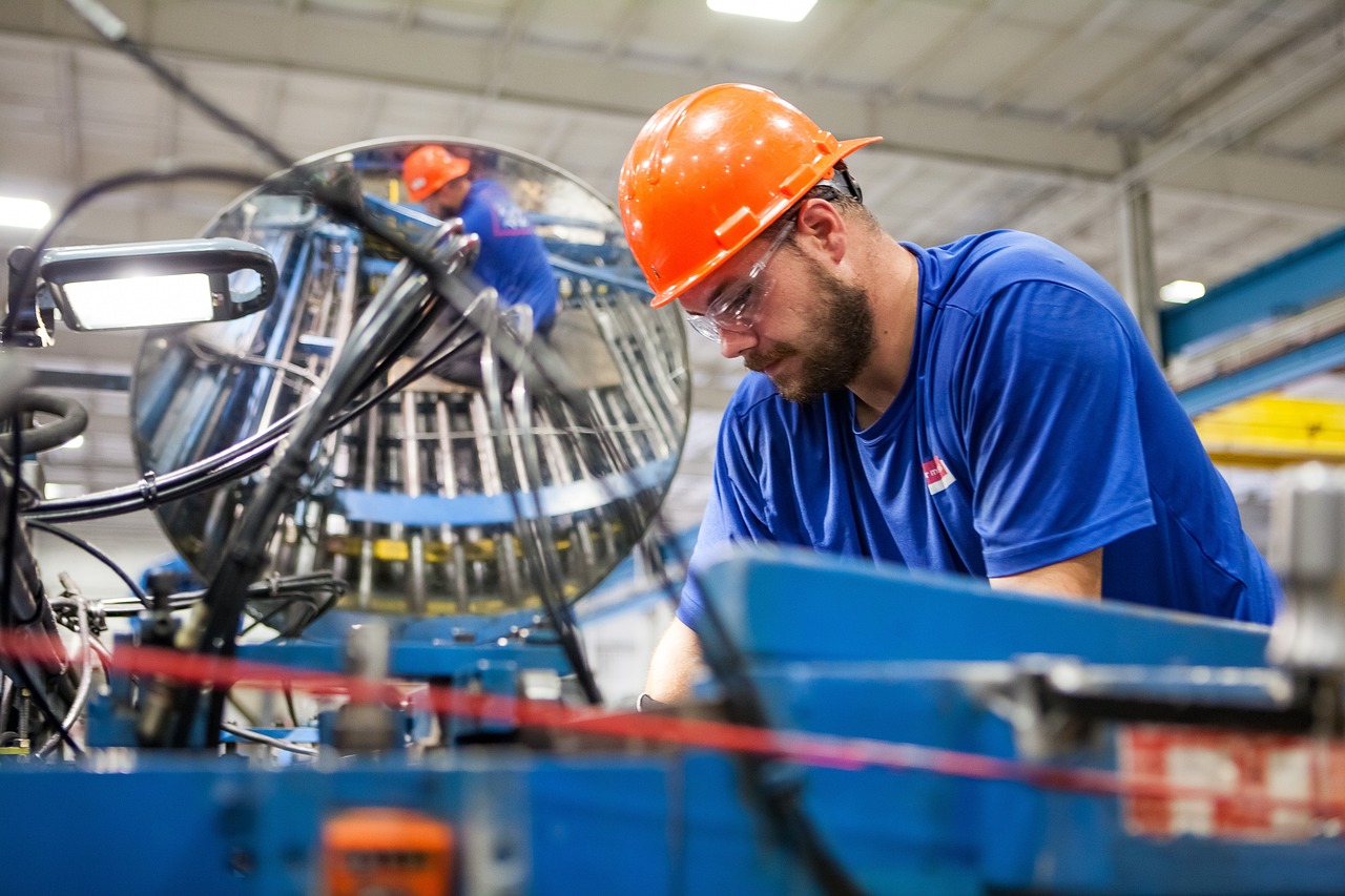 Man in orange hat working in a manufacturing facility 